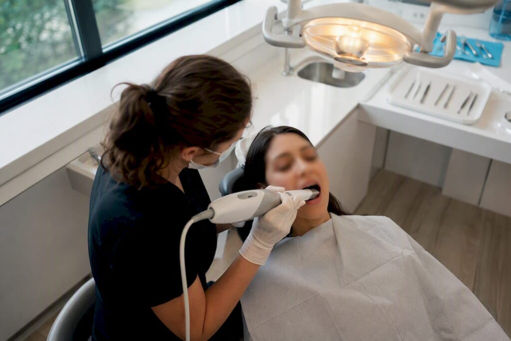 Dental professional scanning patient’s teeth
