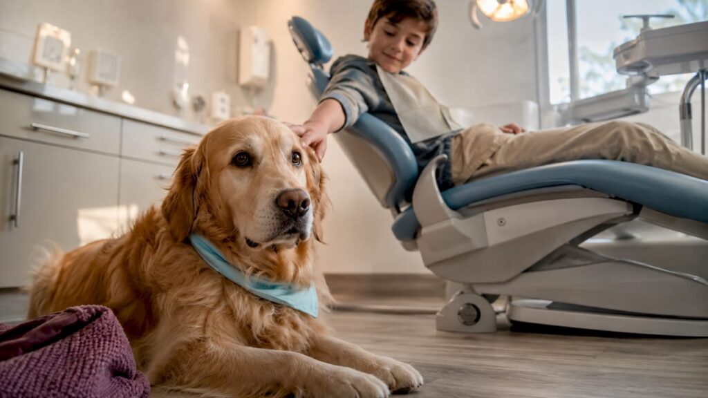 Therapy dog beside child at dental chair