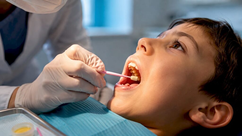 Clinician applying fluoride varnish during preventive care